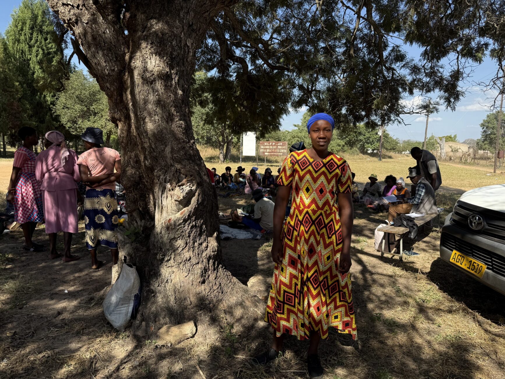 Lidya standing under a tree, smiling.